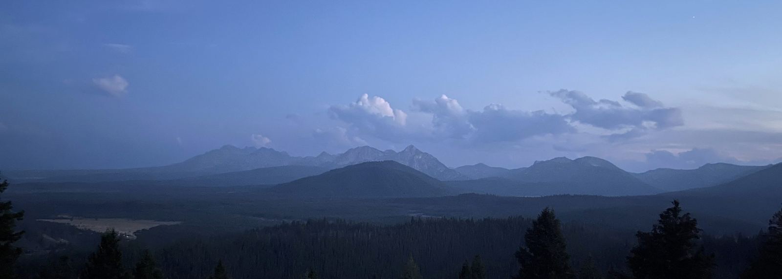 The Sawtooth range in silhouette at blue hour above a darkening Idaho valley