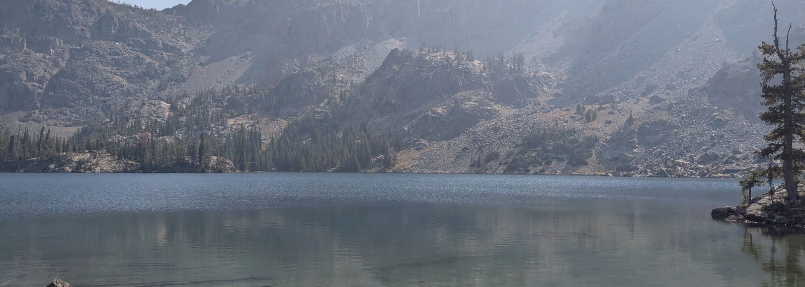 An alpine lake below a granite ridge in the Idaho high country